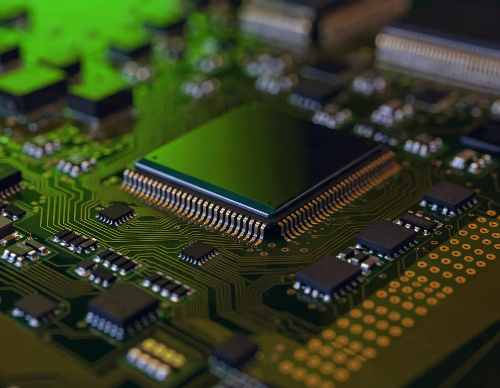 Close-up of a printed circuit board with a central microprocessor and copper traces